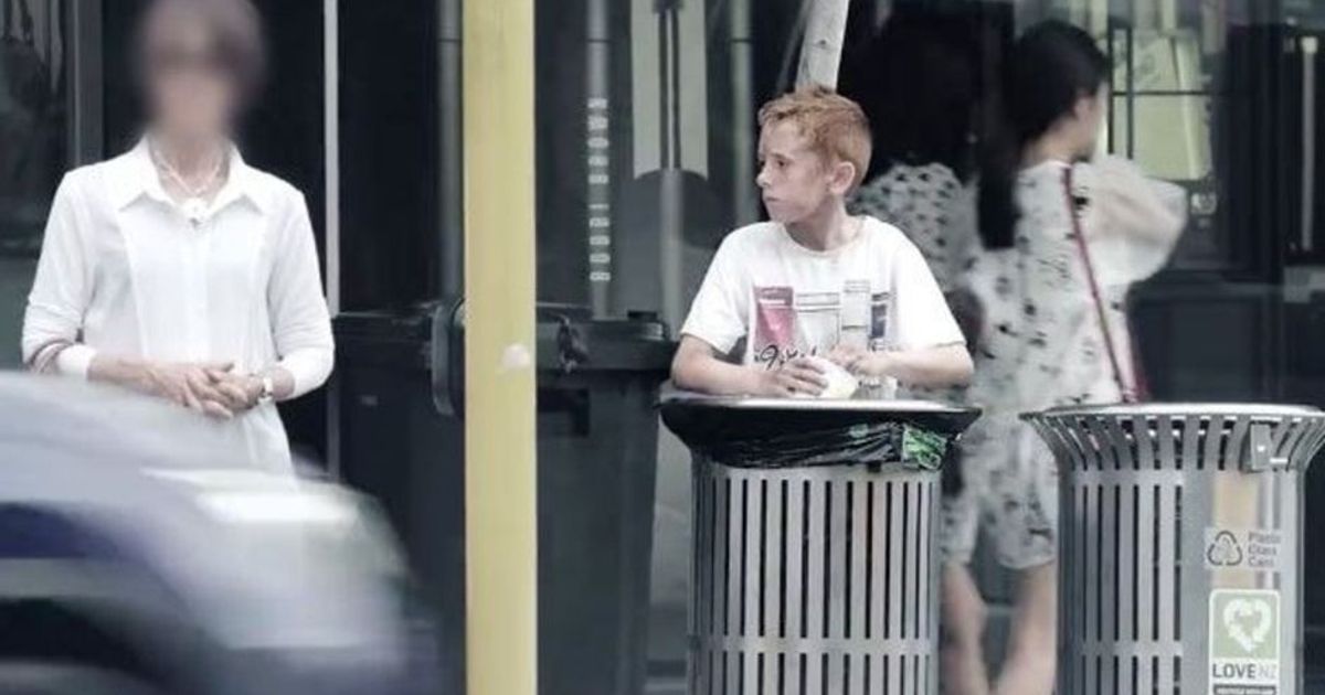 Un ragazzo mangia dai cassonetti ed i passanti lo ignorano