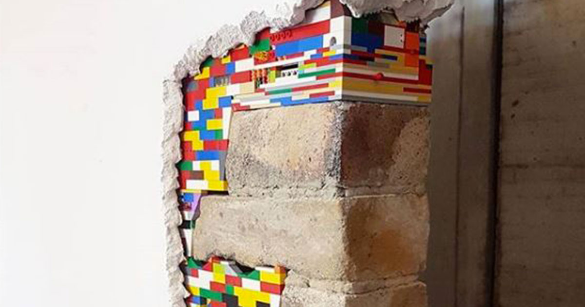 L'artista che copre le crepe dei muri con i Lego