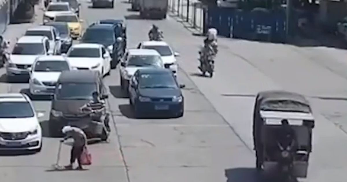 Anziana signora attraversa la strada lentamente, motociclista ferma il traffico
